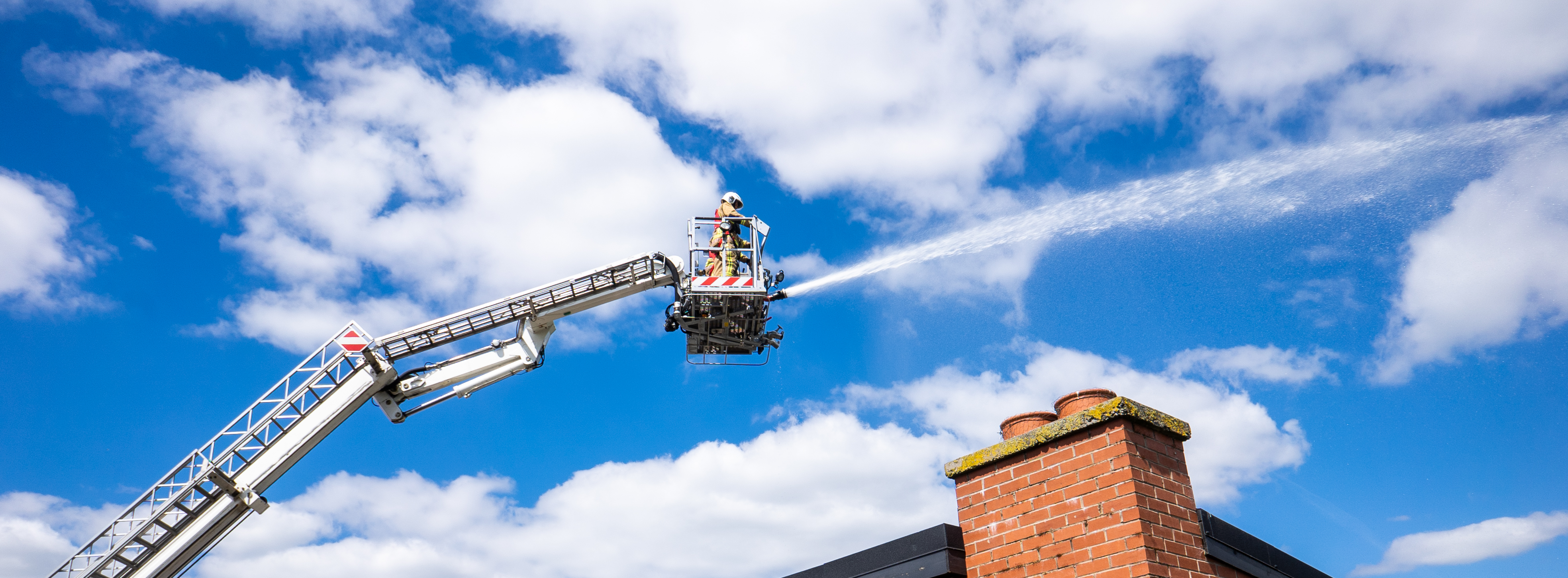 Aerial ladder platform extended and using hose