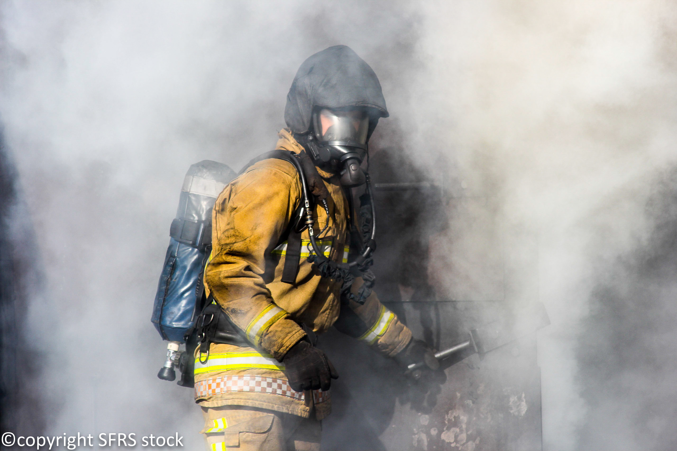 Firefighter coming out of cloud of smoke
