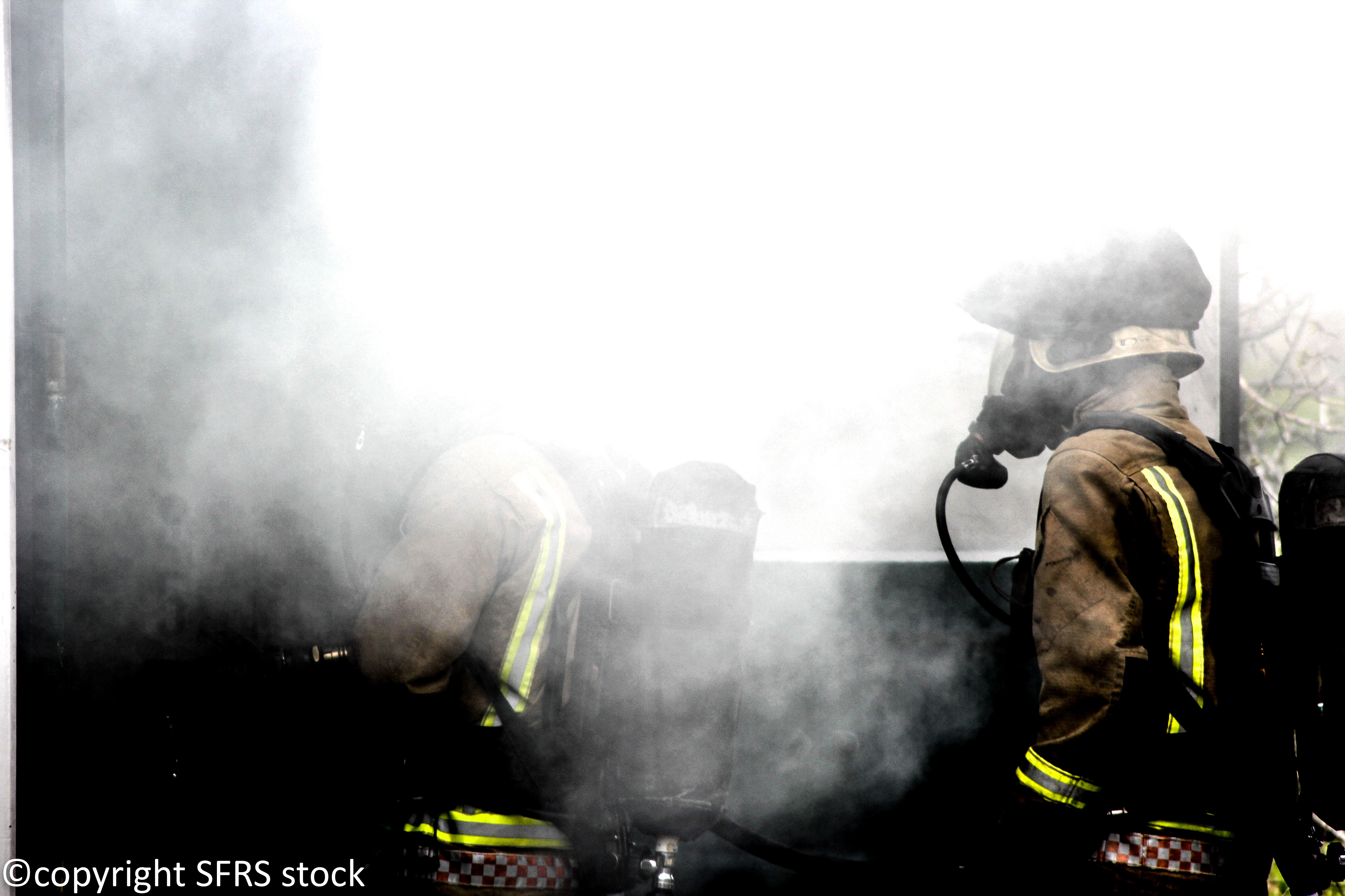 Two firefighters in smoke-filled room