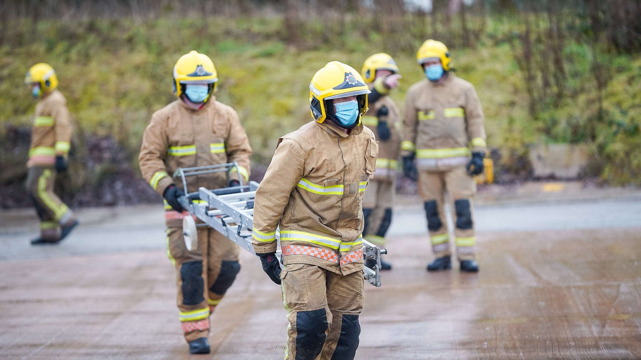 Two firefighters carrying a ladder