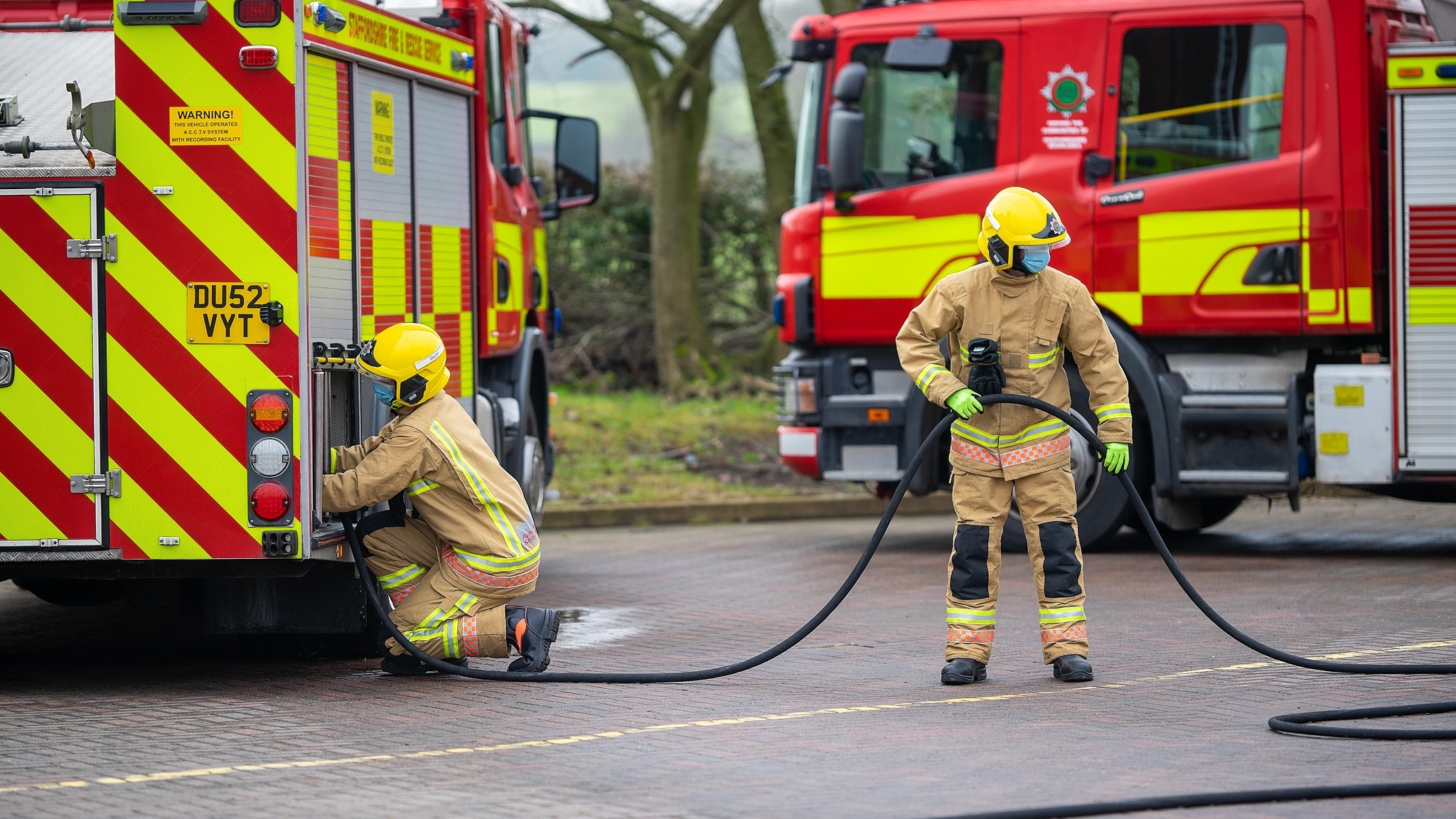 Two firefighters using hose
