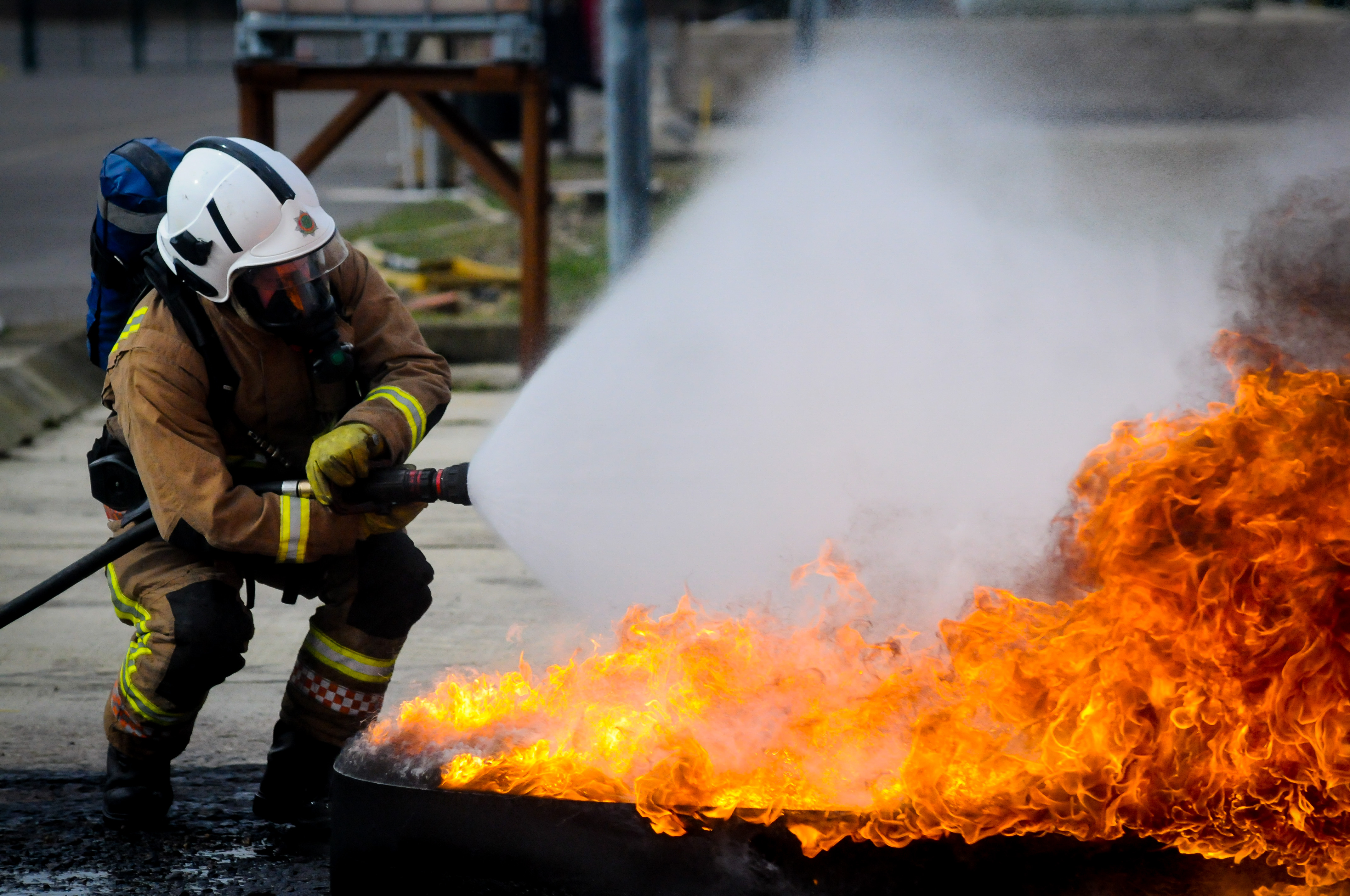 Station manager extinguishing a fire with a hose