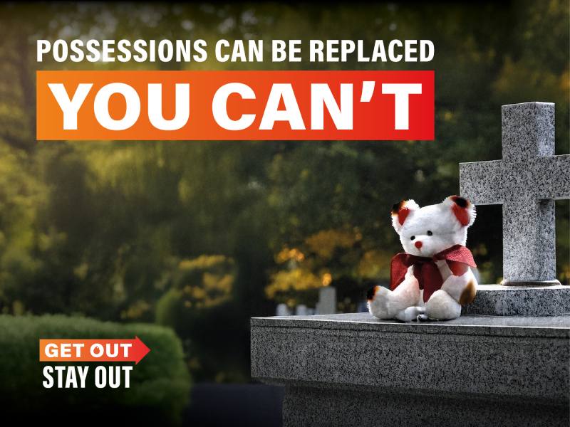 Teddy bear sitting on top of grave stone
